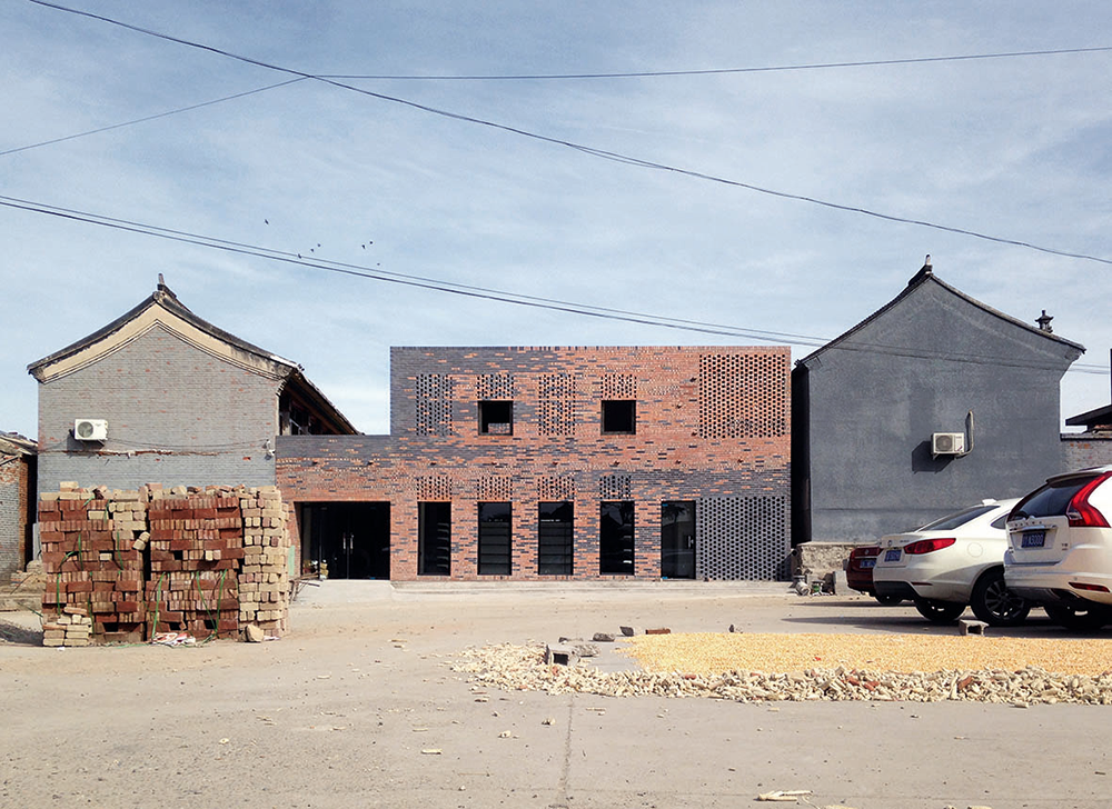 Das Pfirsichhaus am Stadtrand von Peking ist das Ergebnis einer intensiven Auseinandersetzung mit dem Bautyp des Wohnhofes im ländlichen Nordchina. Die Architektur, mit der Neubau und Bestand durch angemessenen Umgang vereint werden sollen, setzte ein Verständnis des Kontextes und der Bauhistorie voraus. Für den Erfolg des Projektes war die Partizipation von lokalen Handwerkern unabdingbar. Recycelte blaue und rote Ziegel ergänzen und definieren die Fassade des Projektes.